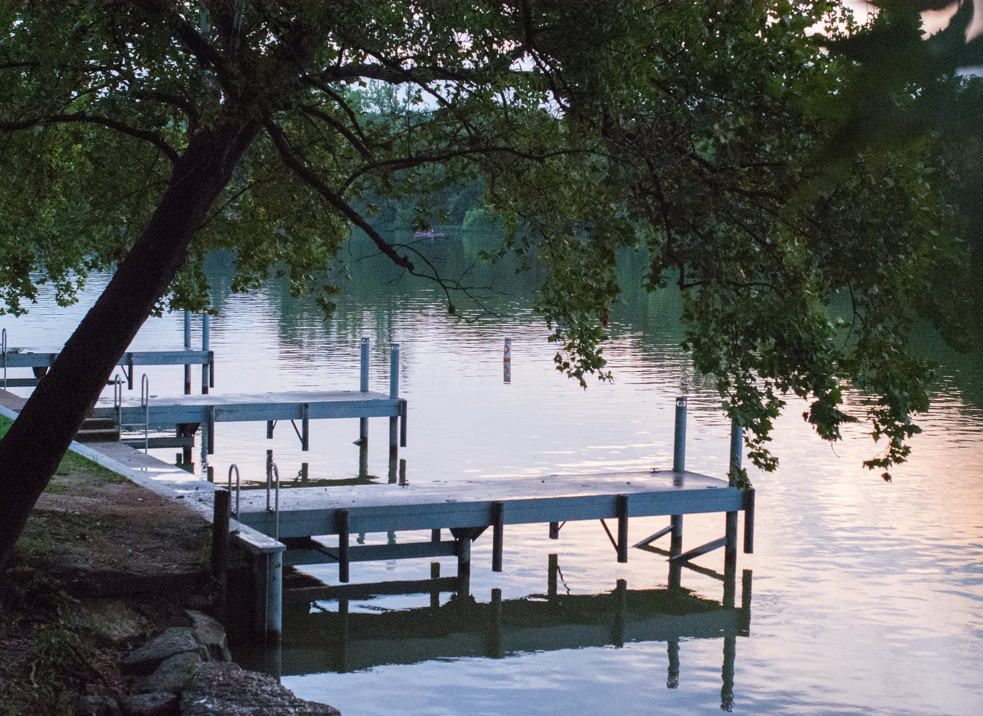 Apache Shores day docks reflected in calm Lake Austin water at dusk